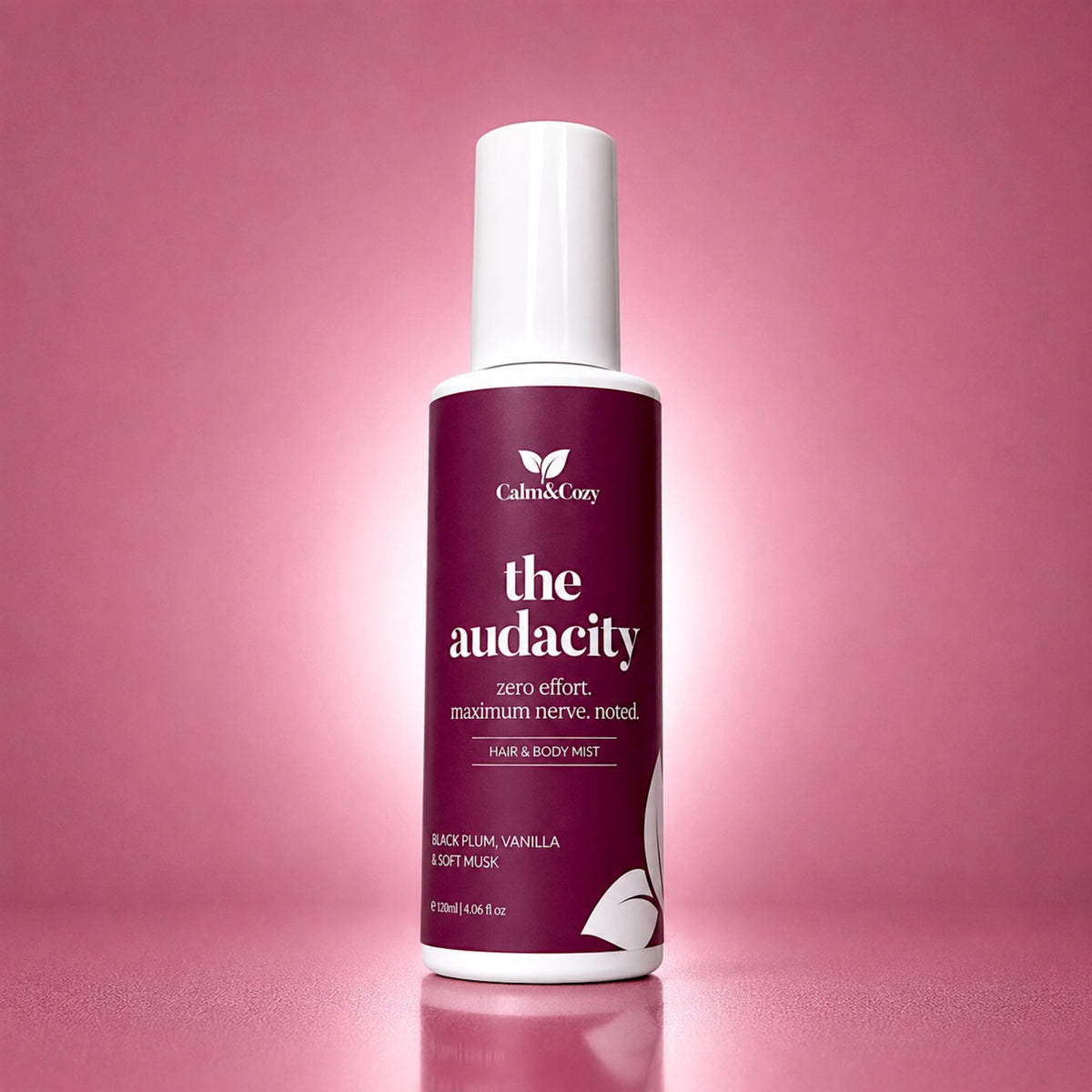 Hair and body mist bottle labeled 'the audacity' on a pink background